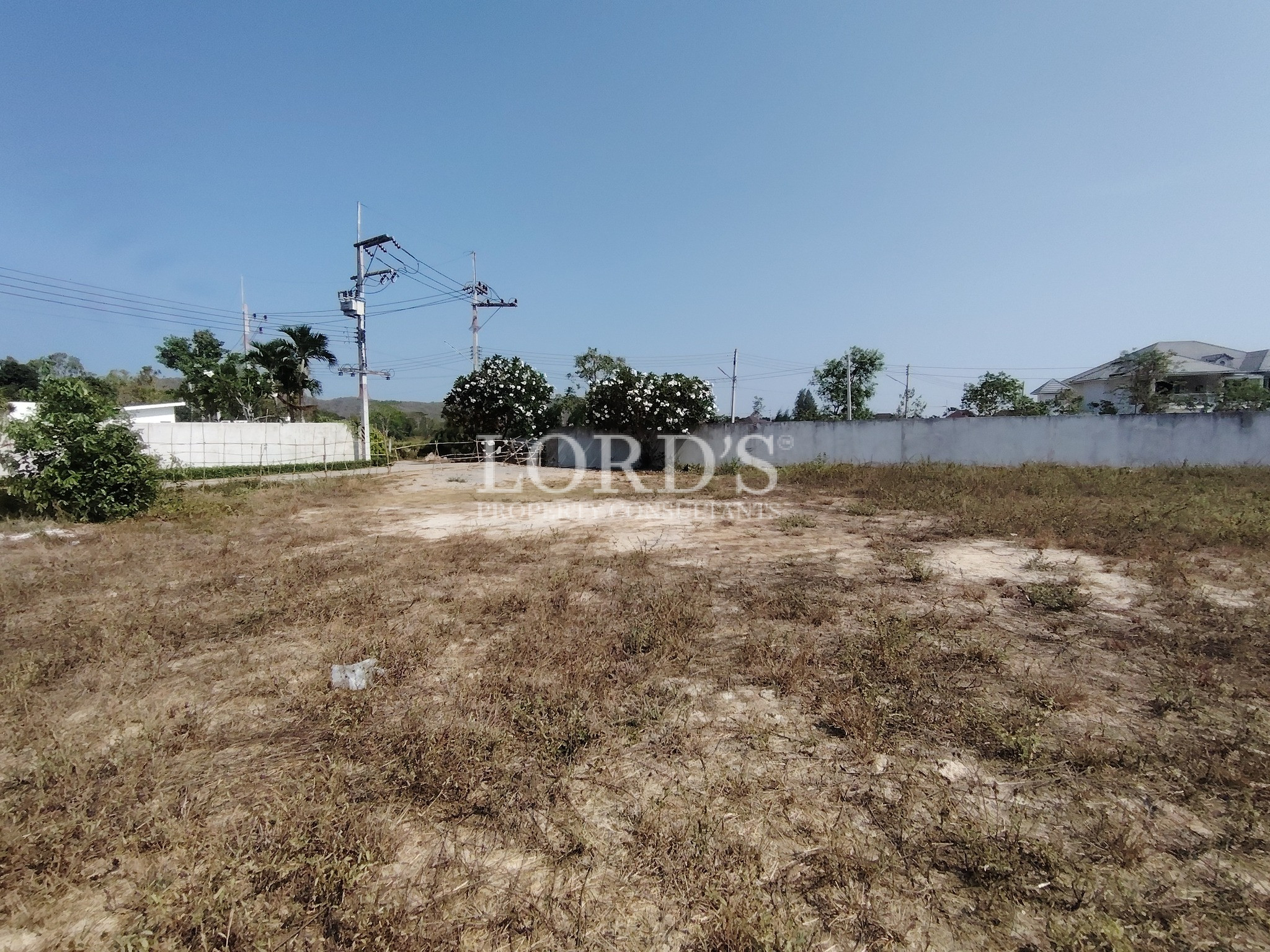 Vacant land with grass and distant houses