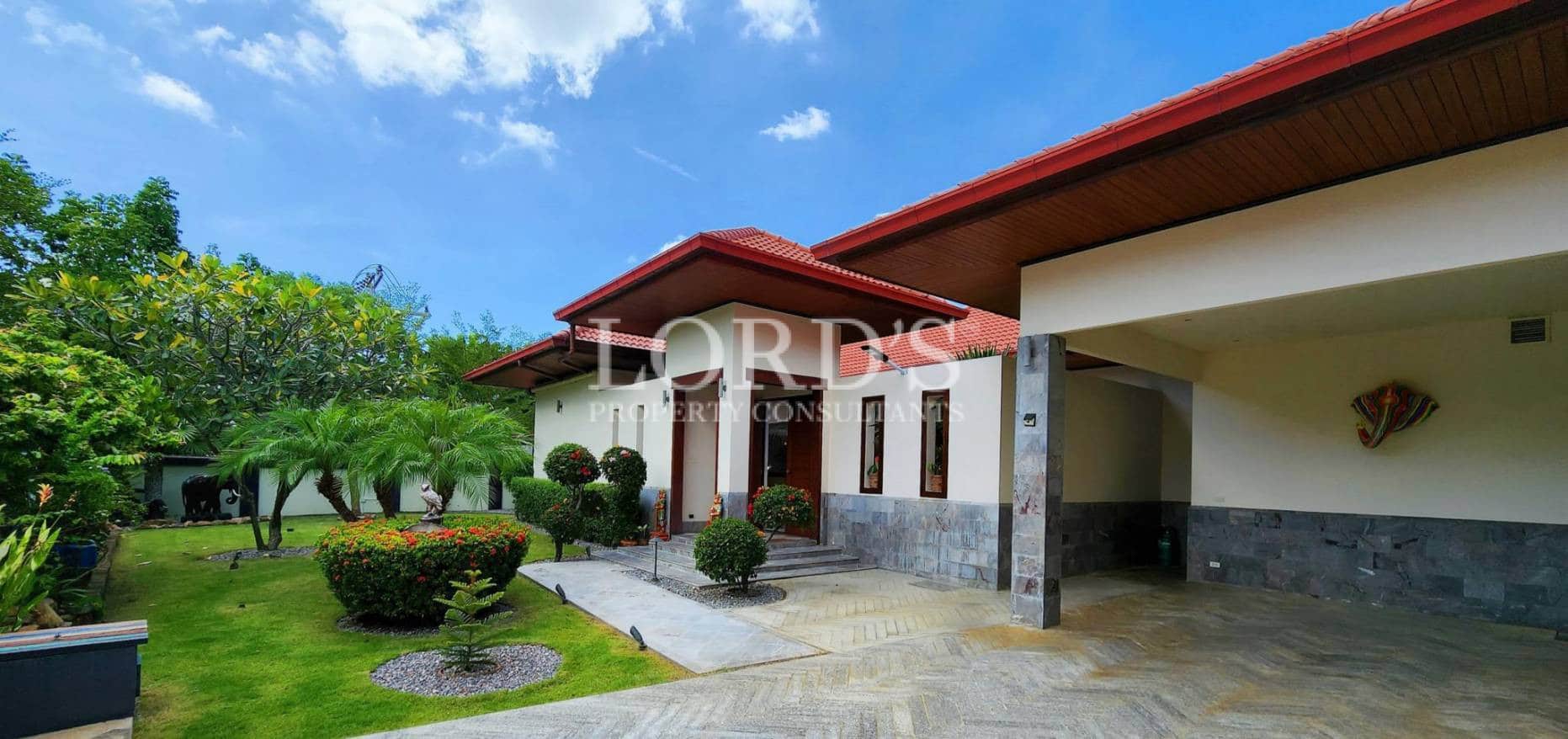 Villa exterior with lawn and entrance path