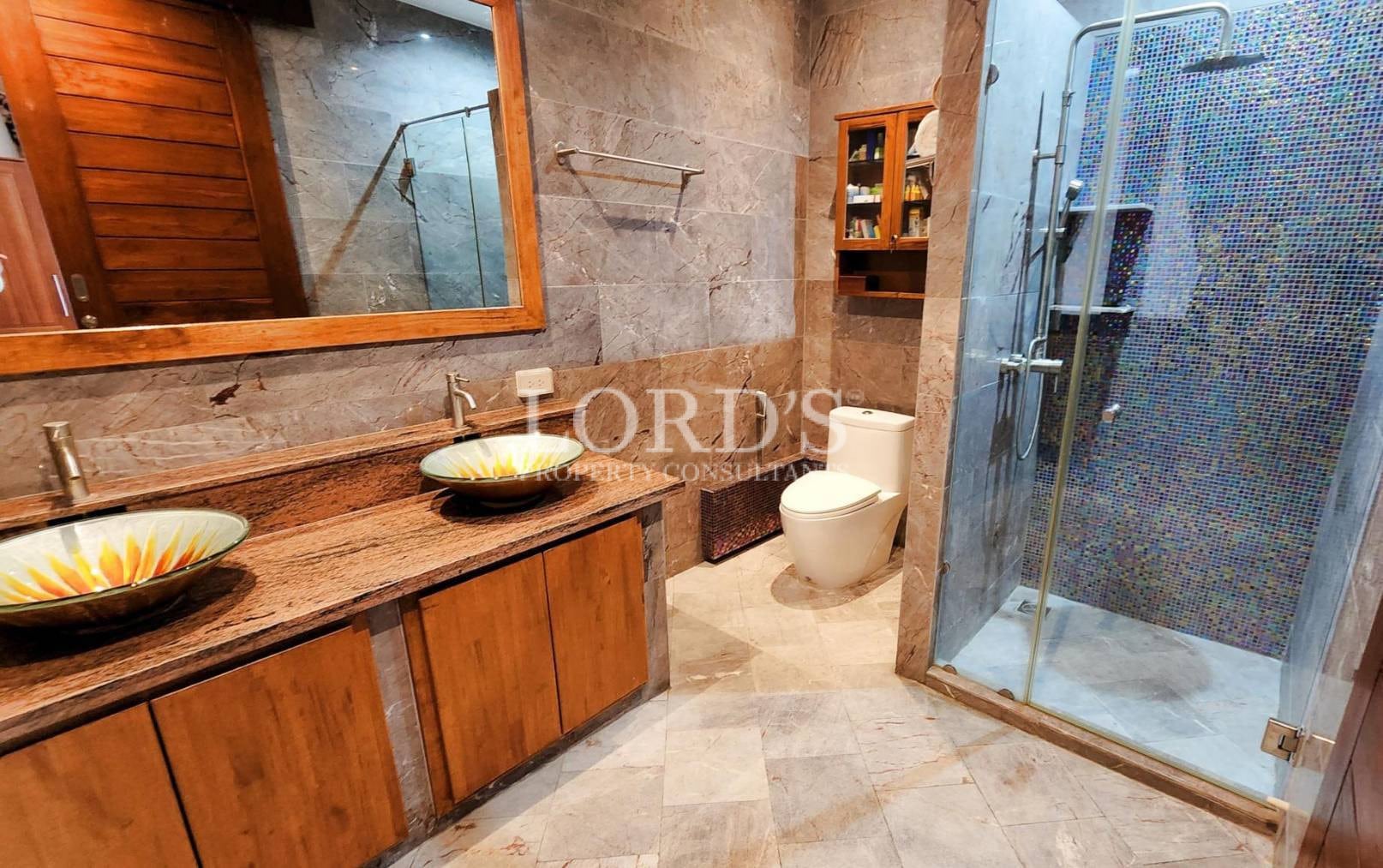 Bathroom with wooden vanity and glass shower