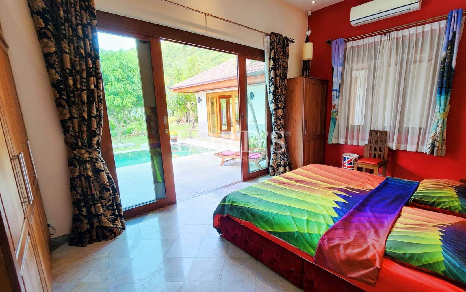 Bedroom with bright bedding and open doors to patio
