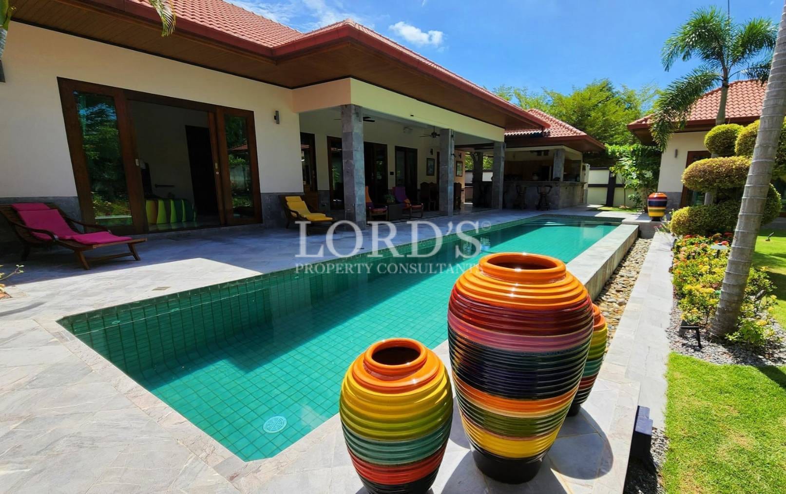 Poolside with decorative pots and villa view