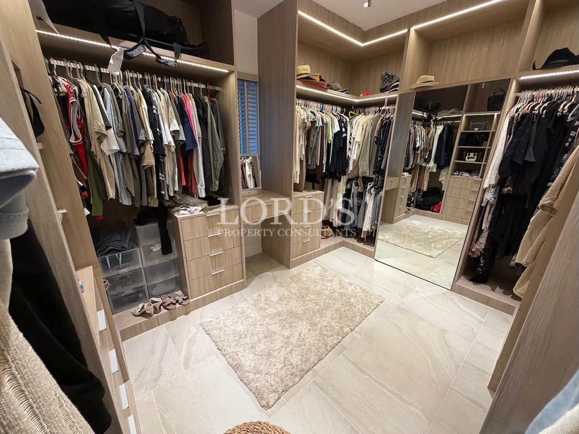 Walk-in closet with clothes and storage