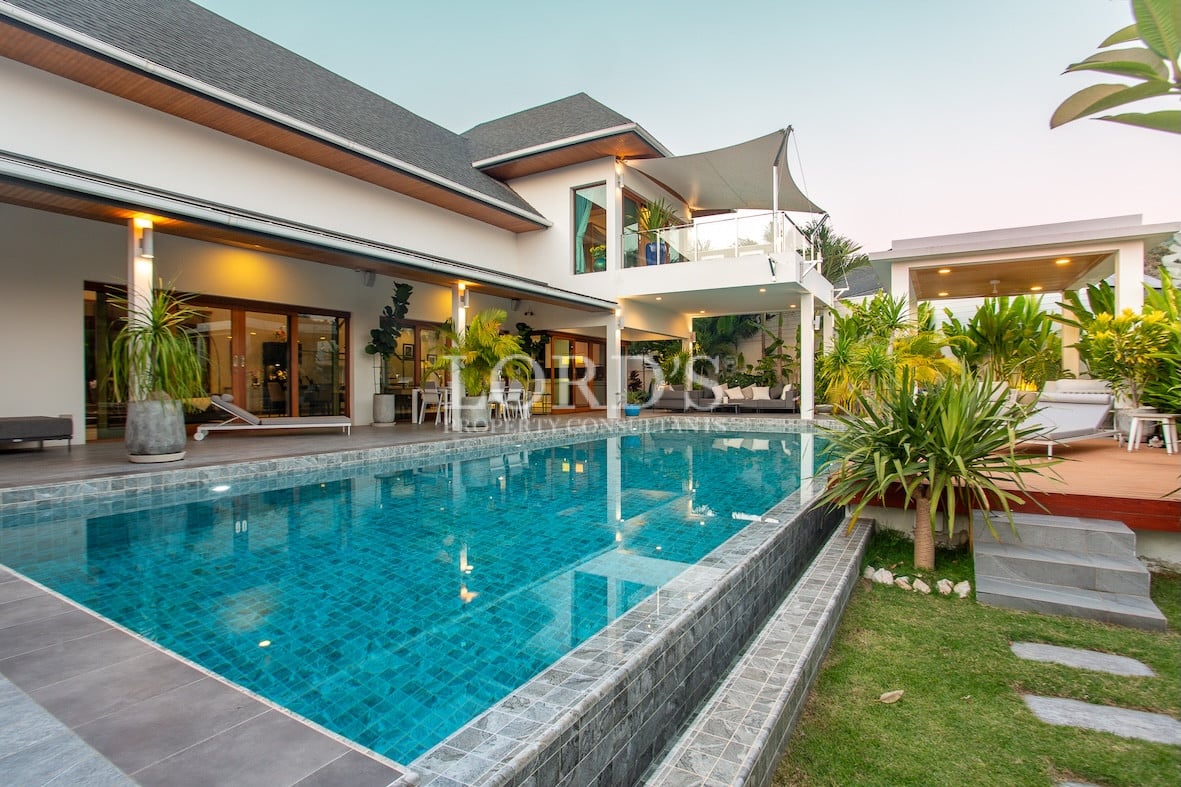 Pool with villa and tropical landscaping