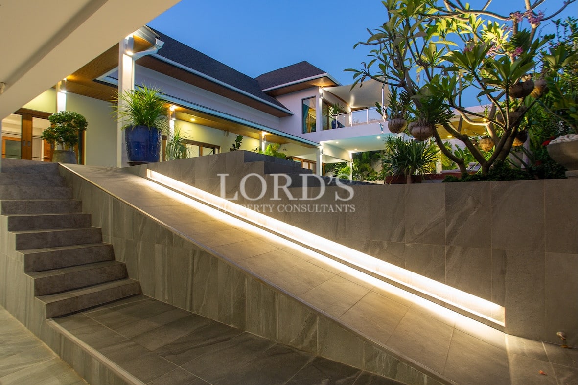 Villa exterior with steps and modern lighting at dusk