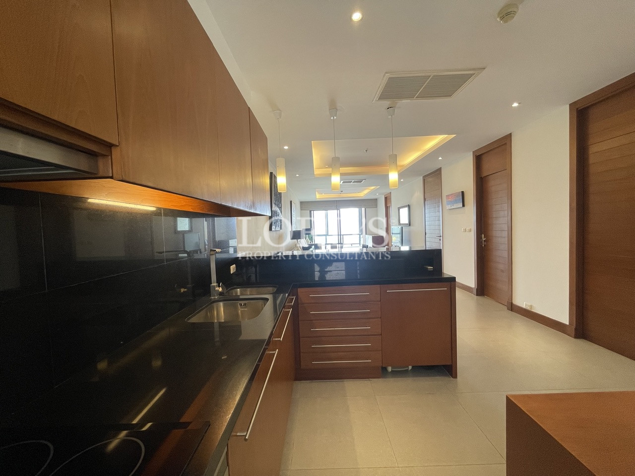 Long kitchen with black countertop and cabinets