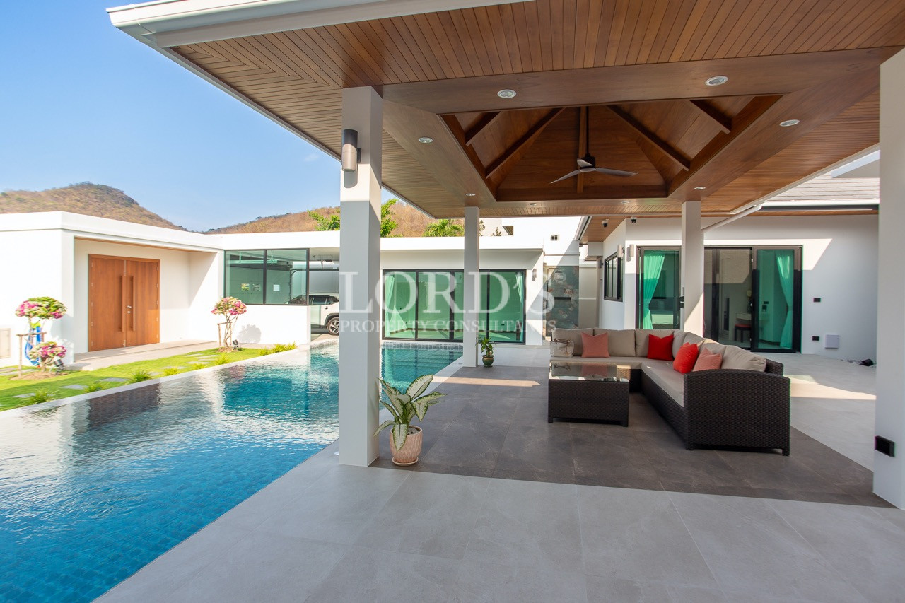 covered outdoor patio with pool and seating area