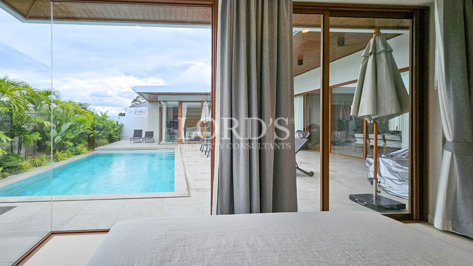Bedroom with curtains and pool view