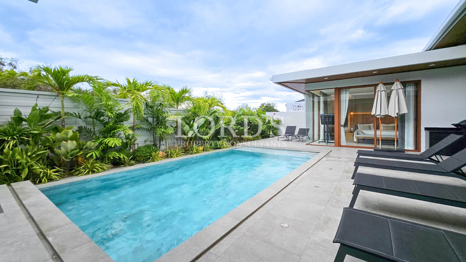 Long swimming pool beside modern house
