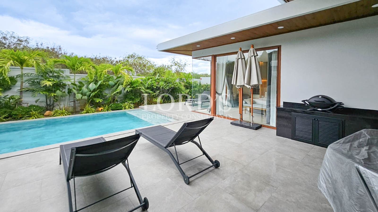 Poolside seating area with modern villa