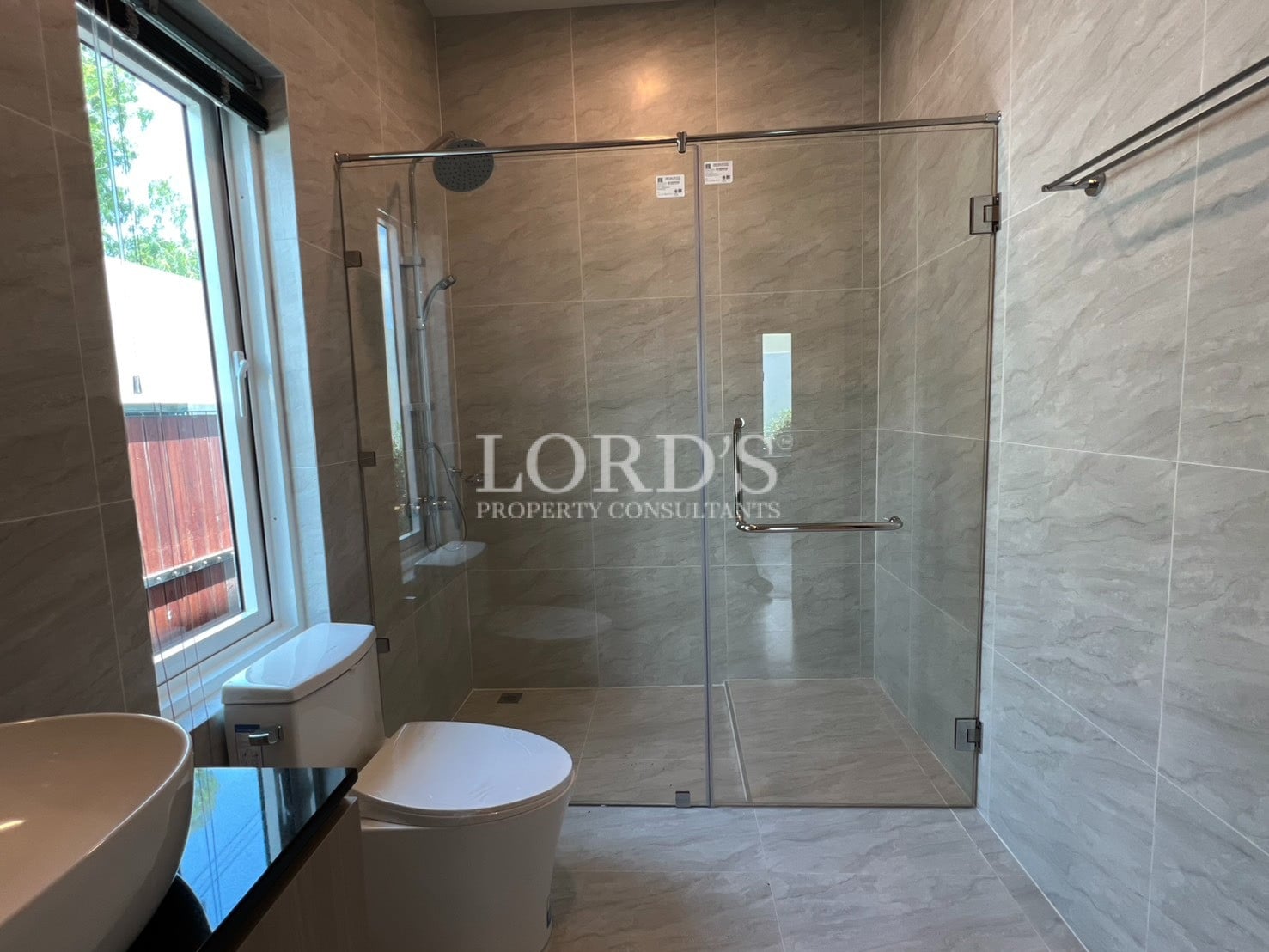 Bathroom with glass shower and tiled walls