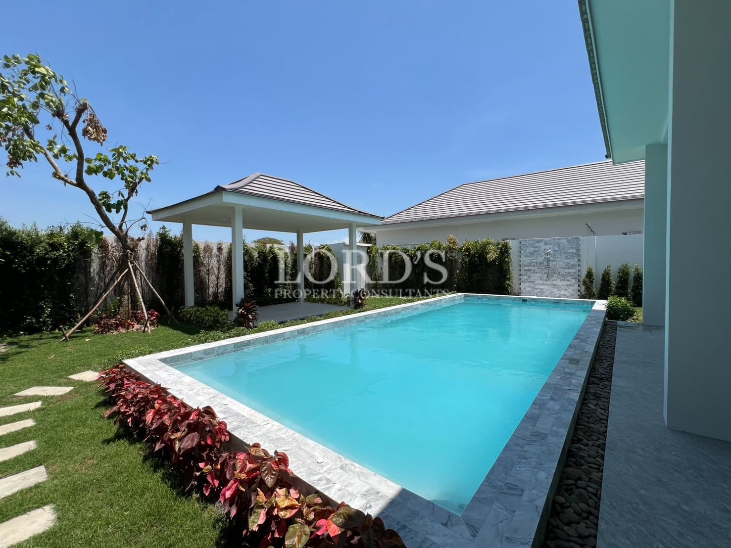 Pool with villa and landscaped garden
