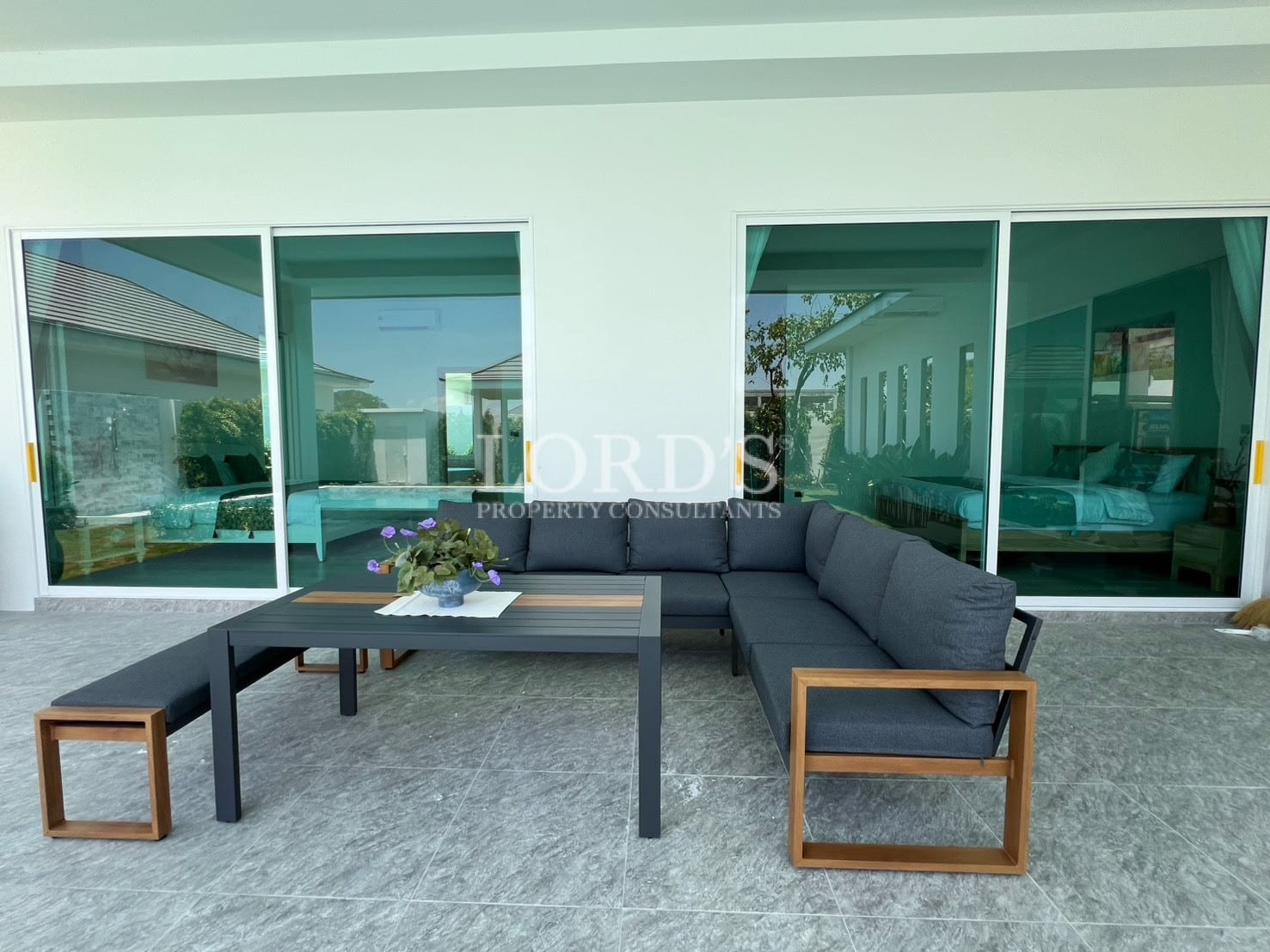 Outdoor lounge with sofa and garden view