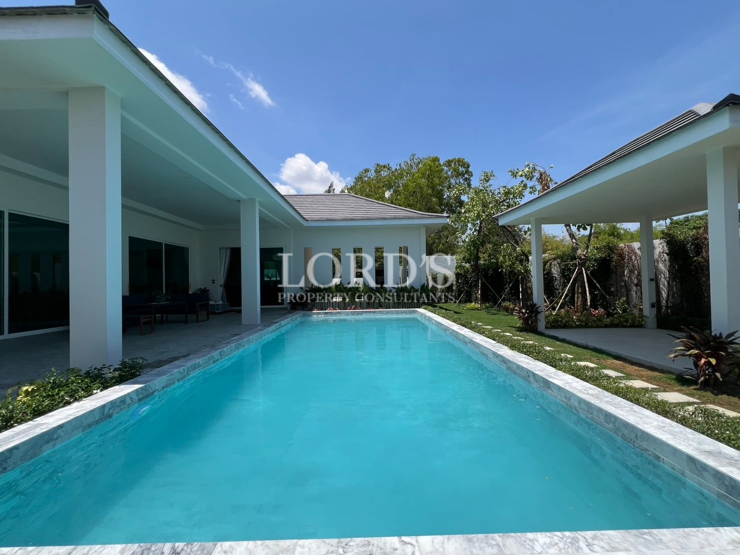 Poolside with villa and blue sky