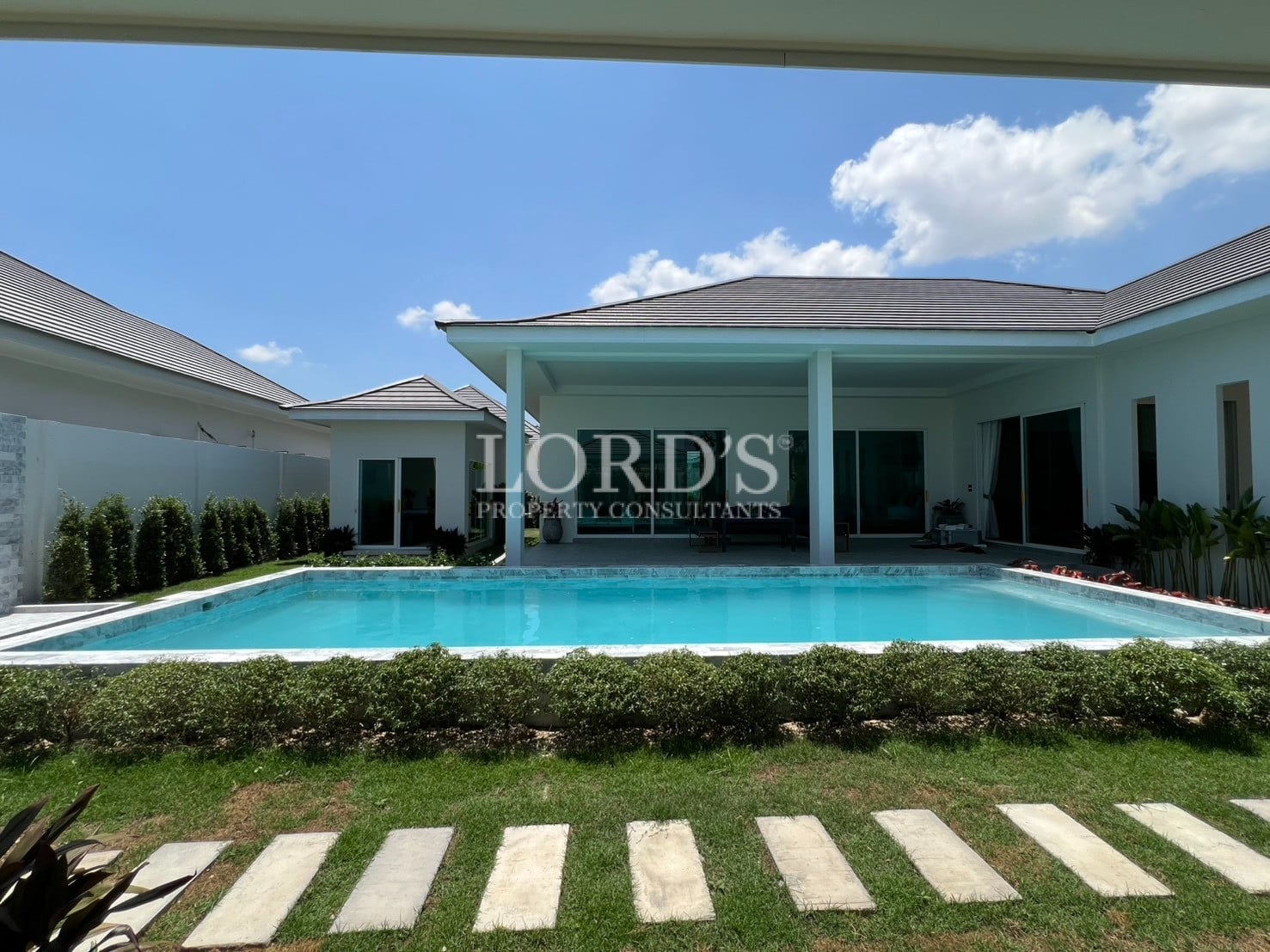 Villa exterior with pool and stepping stone pathway