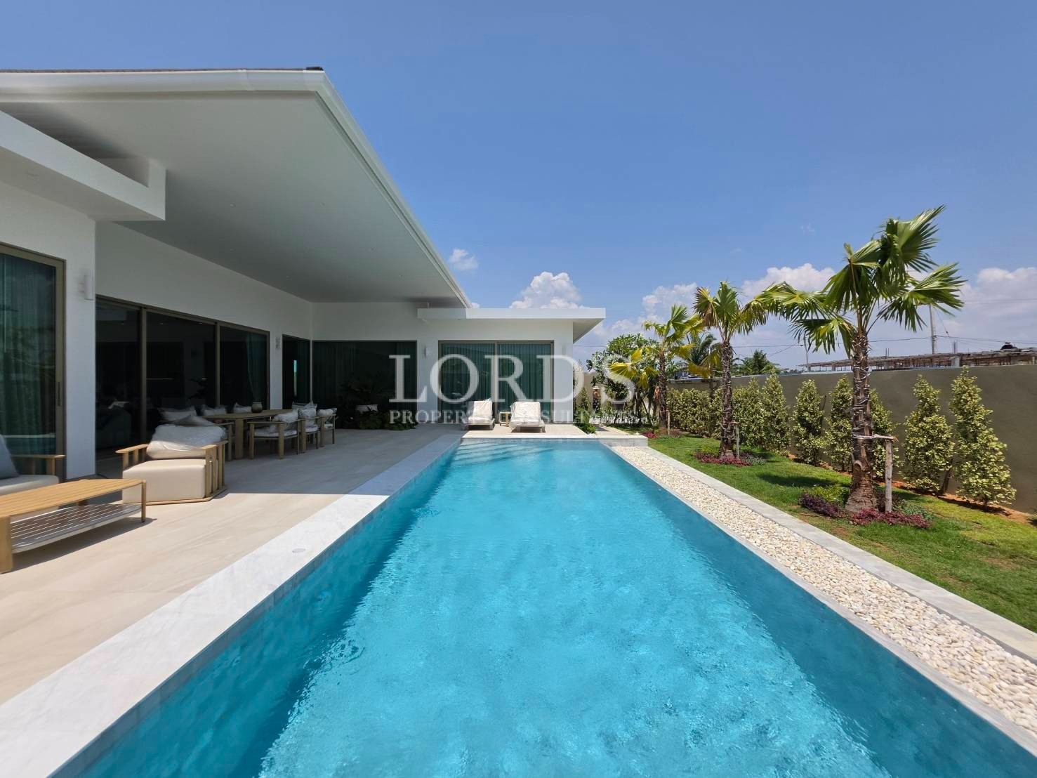 Long swimming pool beside modern villa