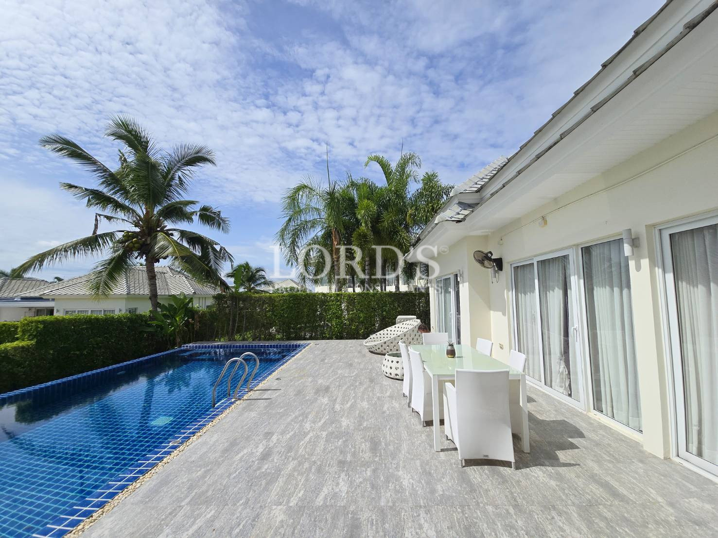 Poolside patio with white chairs