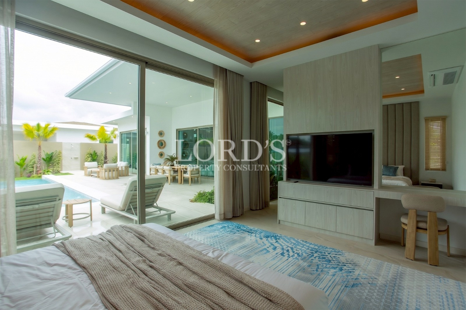 Bedroom with poolside access and TV wall