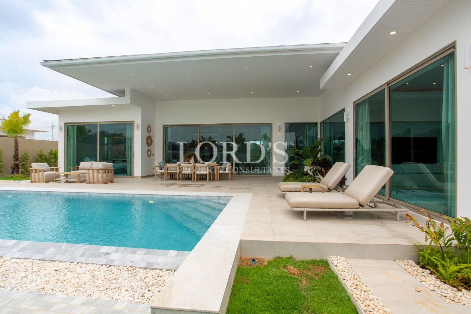 Modern villa with pool and lounge chairs