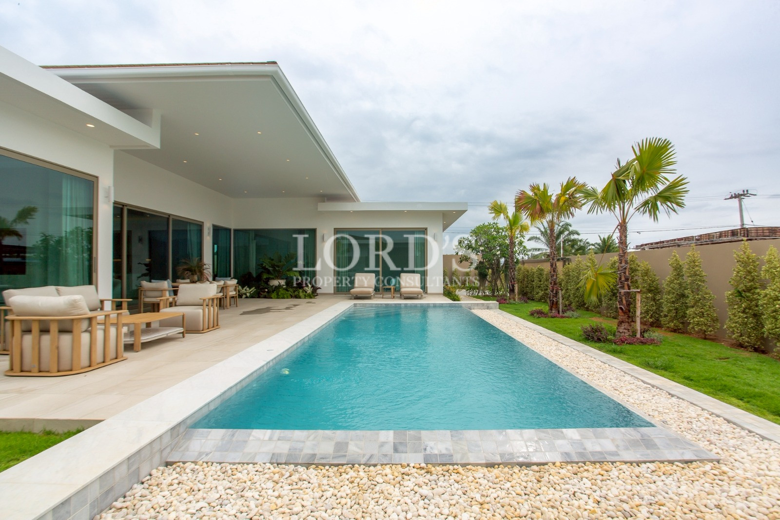 Long rectangular swimming pool beside villa
