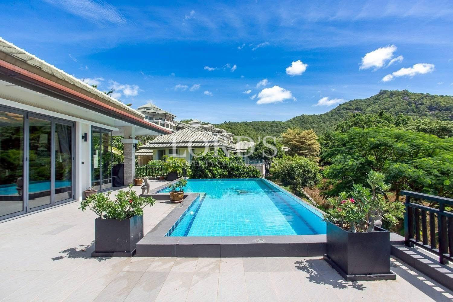 Swimming pool with tropical villa backdrop