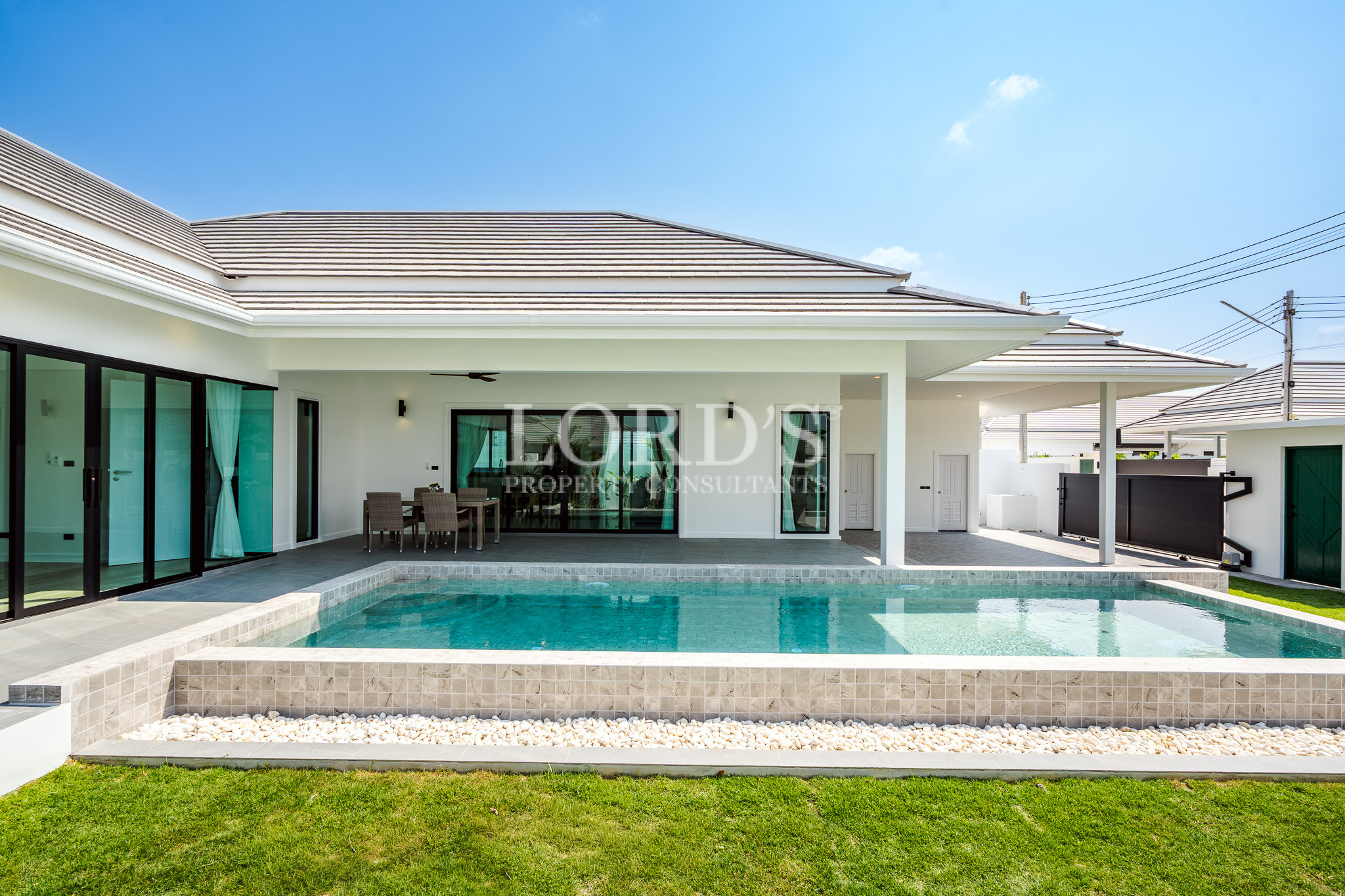Contemporary villa exterior with pool and lawn