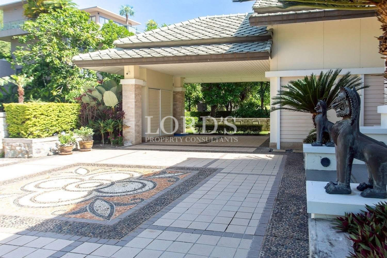 Covered villa entrance with tiled driveway