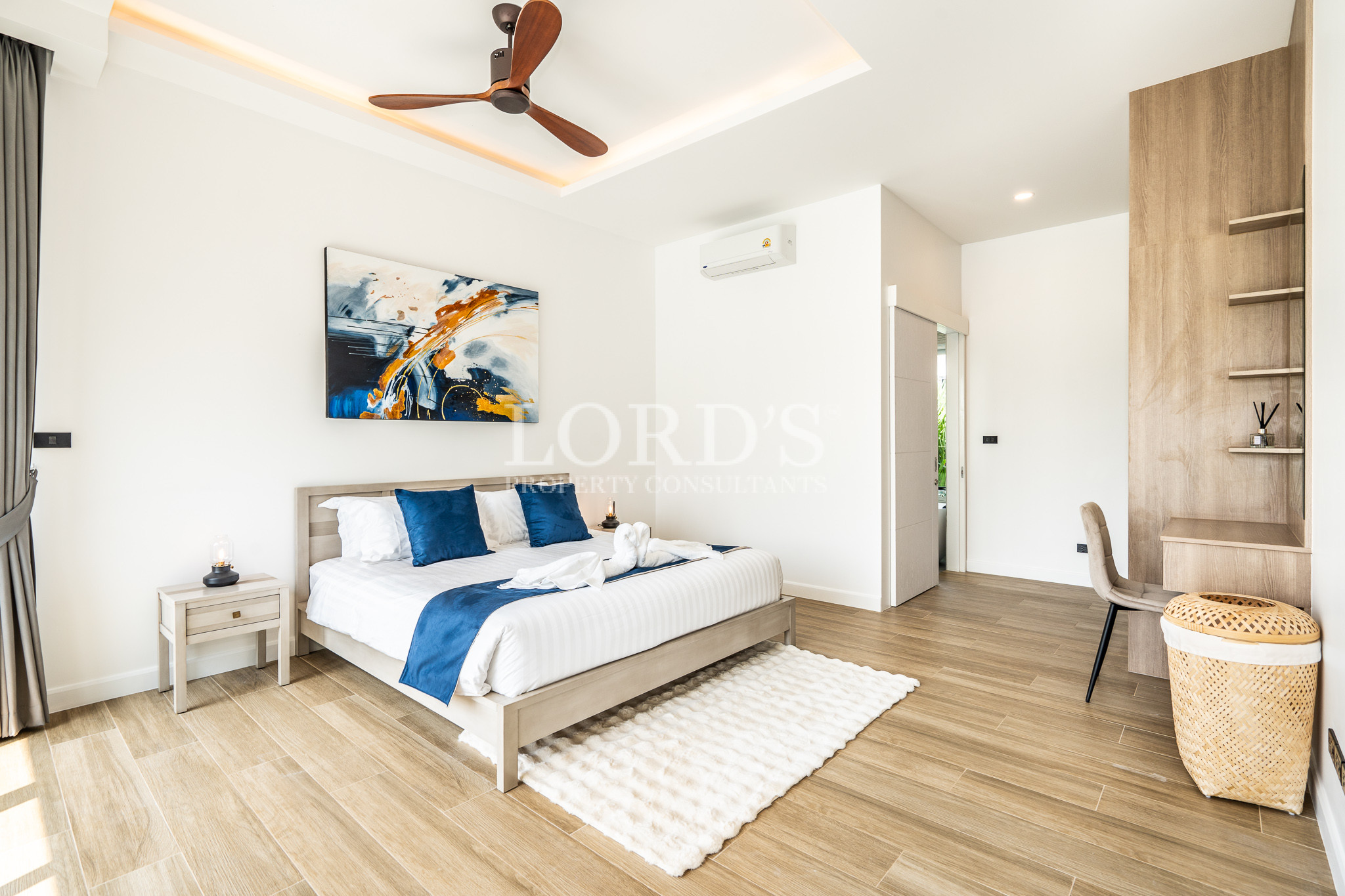 Modern bedroom with blue bedding and ceiling fan