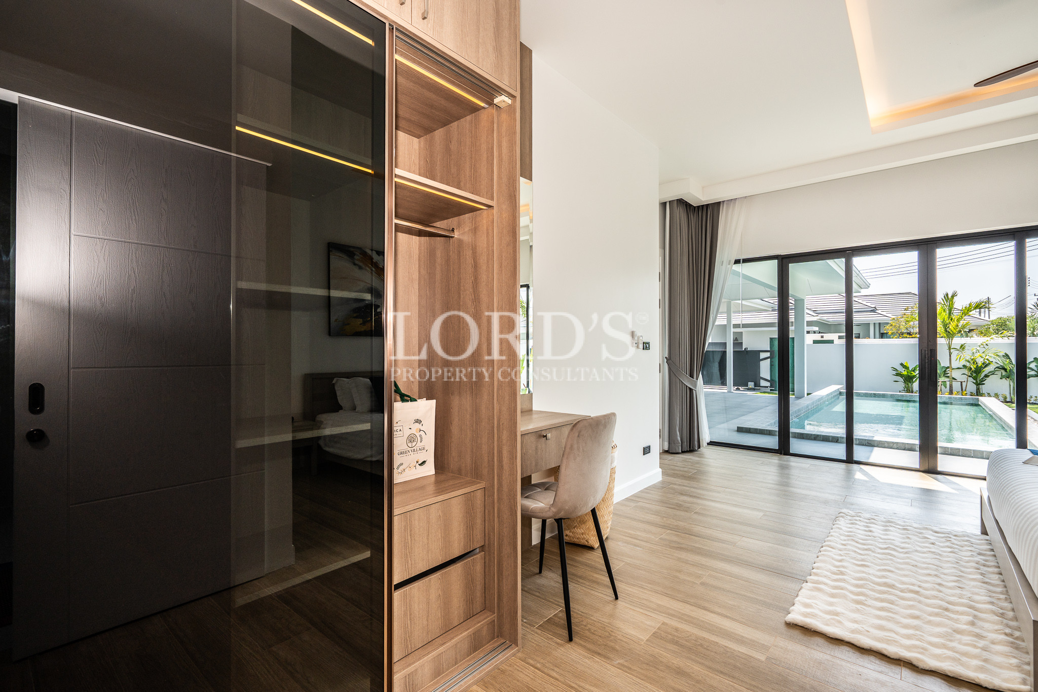 Walk-in closet with illuminated shelving and vanity