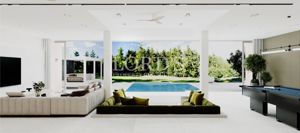 Open-plan living area with large glass doors and greenery view