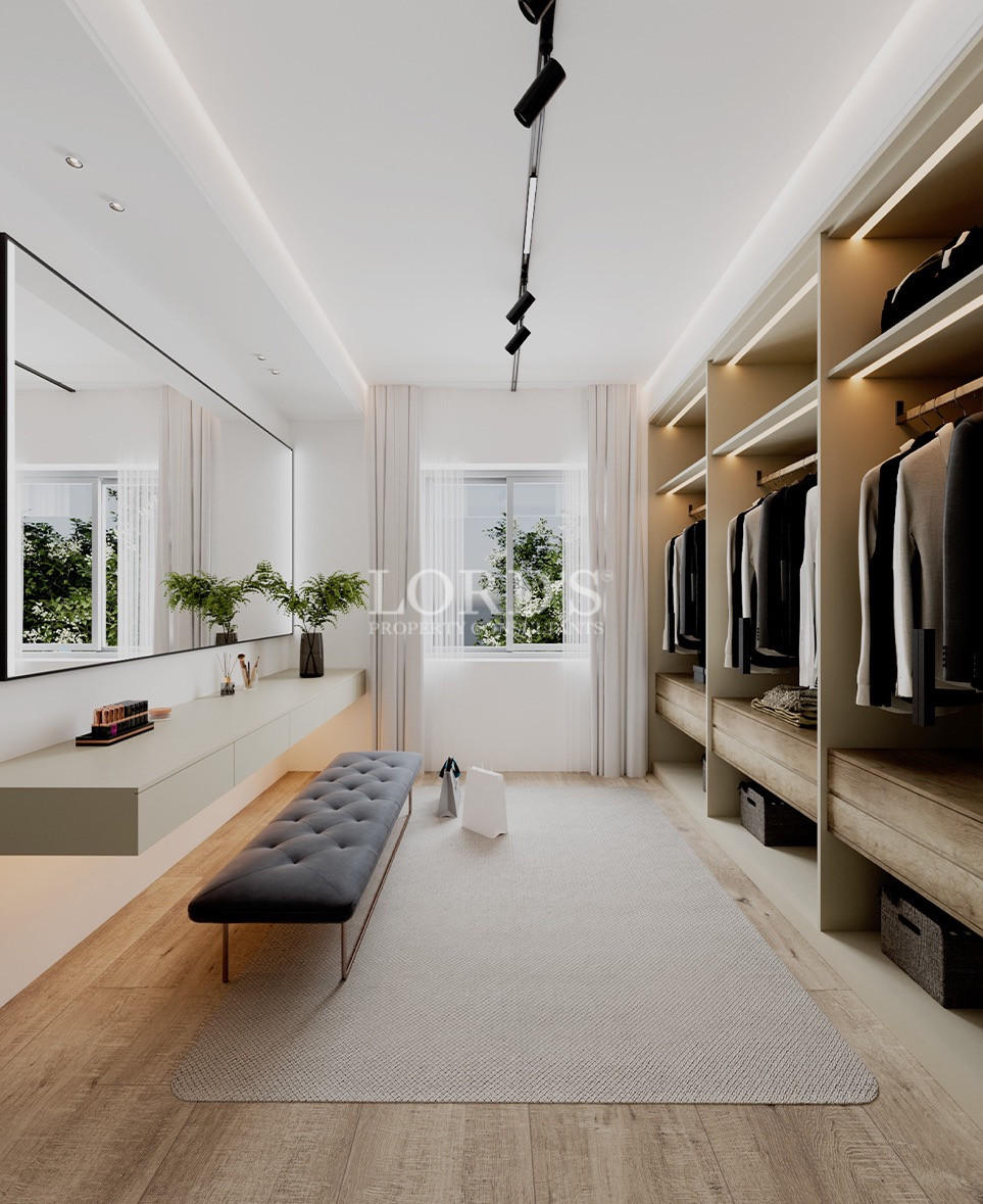 Walk-in closet with illuminated shelving and clothing racks