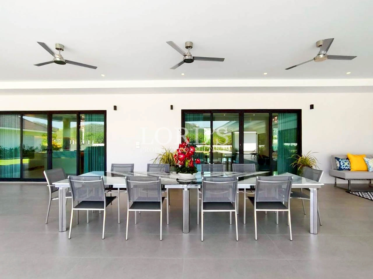 Modern dining area with large windows and ceiling fan