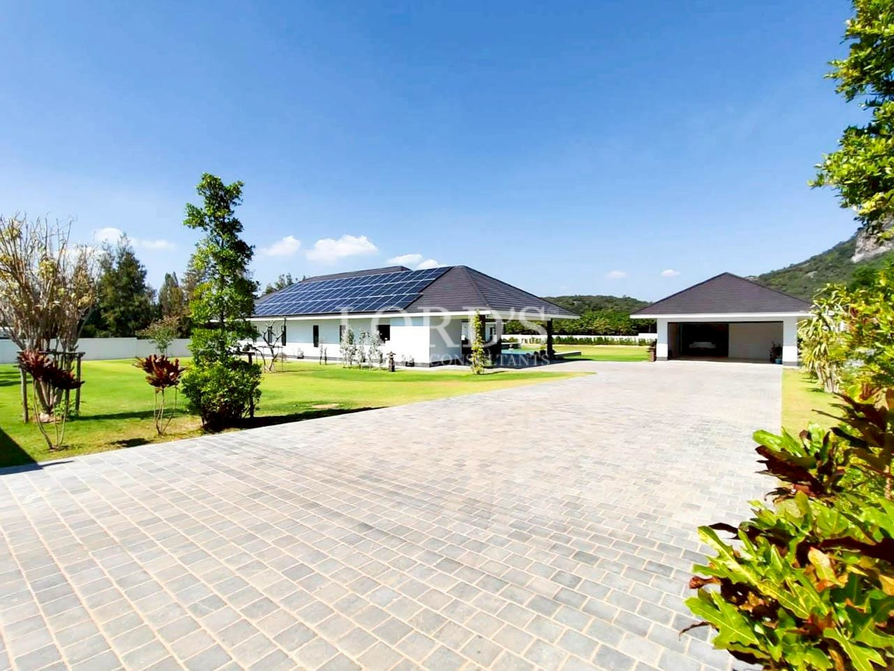 Modern villa exterior with paved driveway and lawn