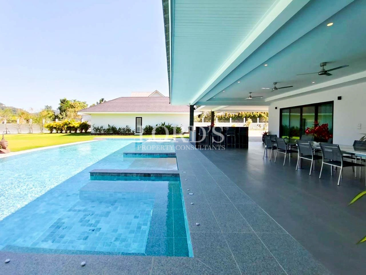 Infinity pool with modern villa and mountain views