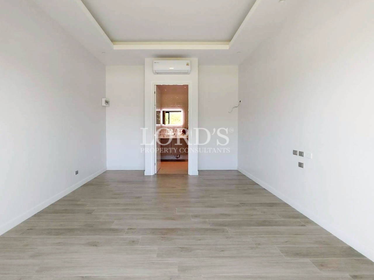 Empty modern room with wooden flooring and recessed ceiling