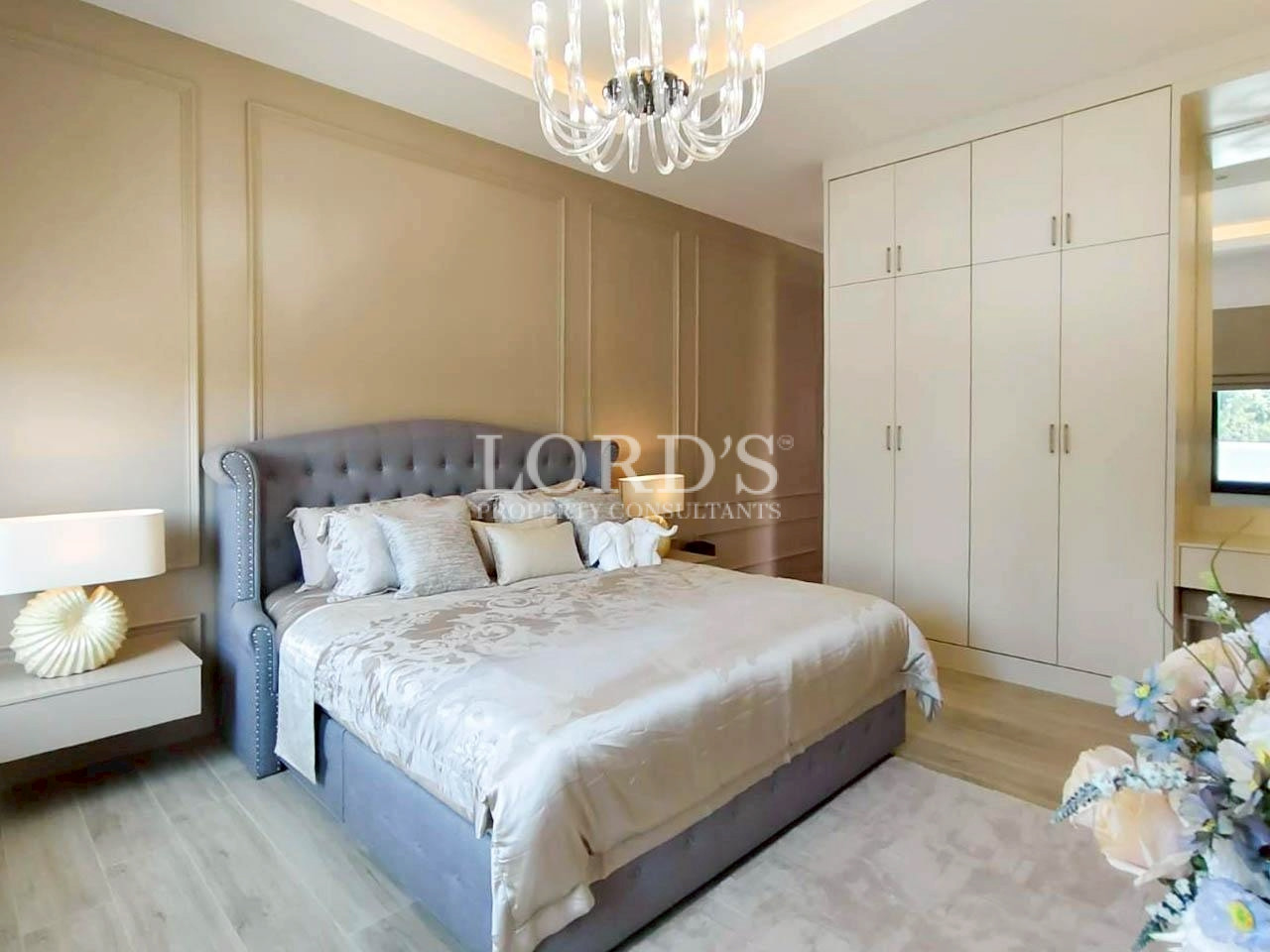 Bright bedroom with tufted headboard and chandelier