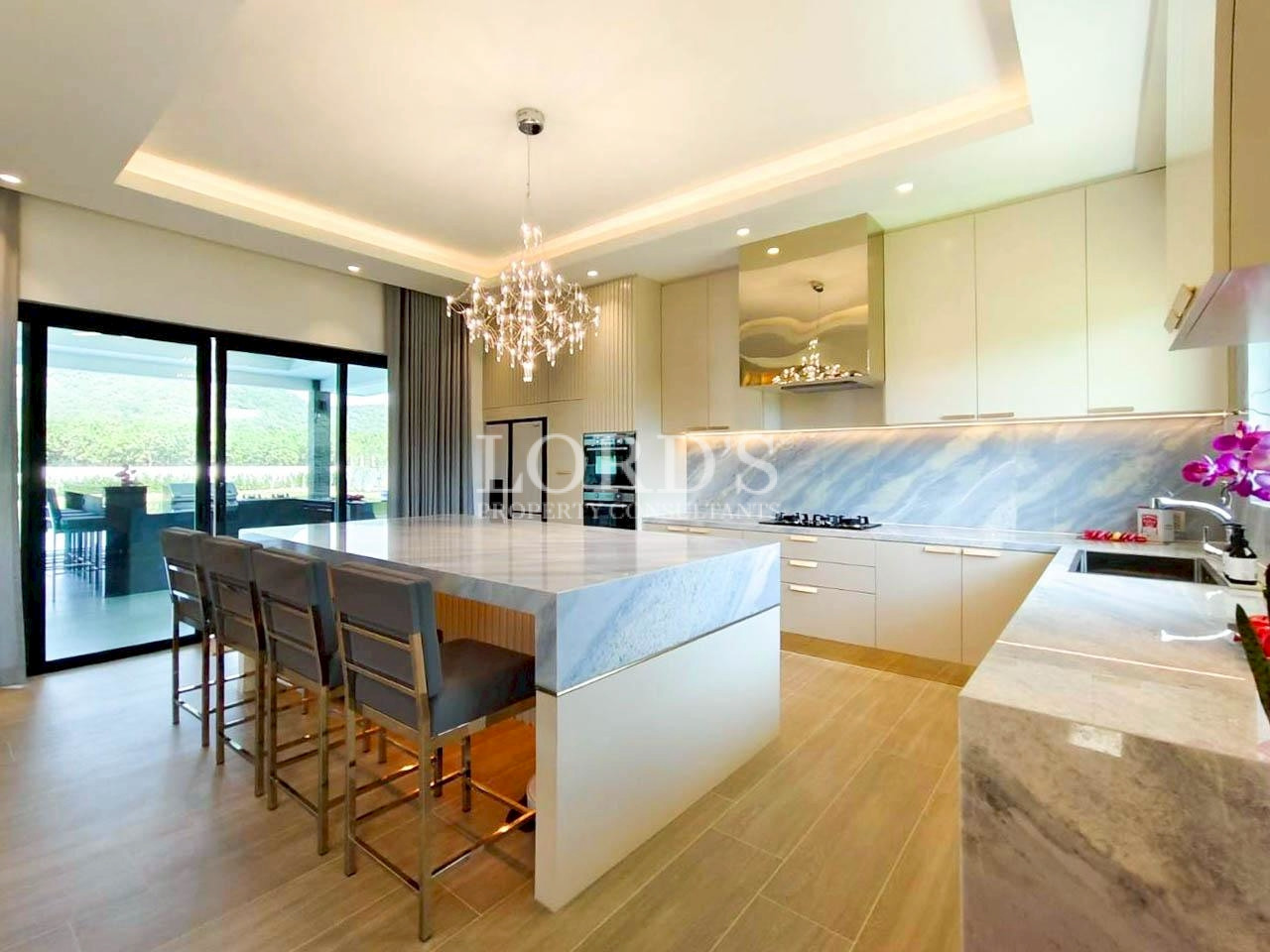 Contemporary kitchen with chandelier and wooden flooring