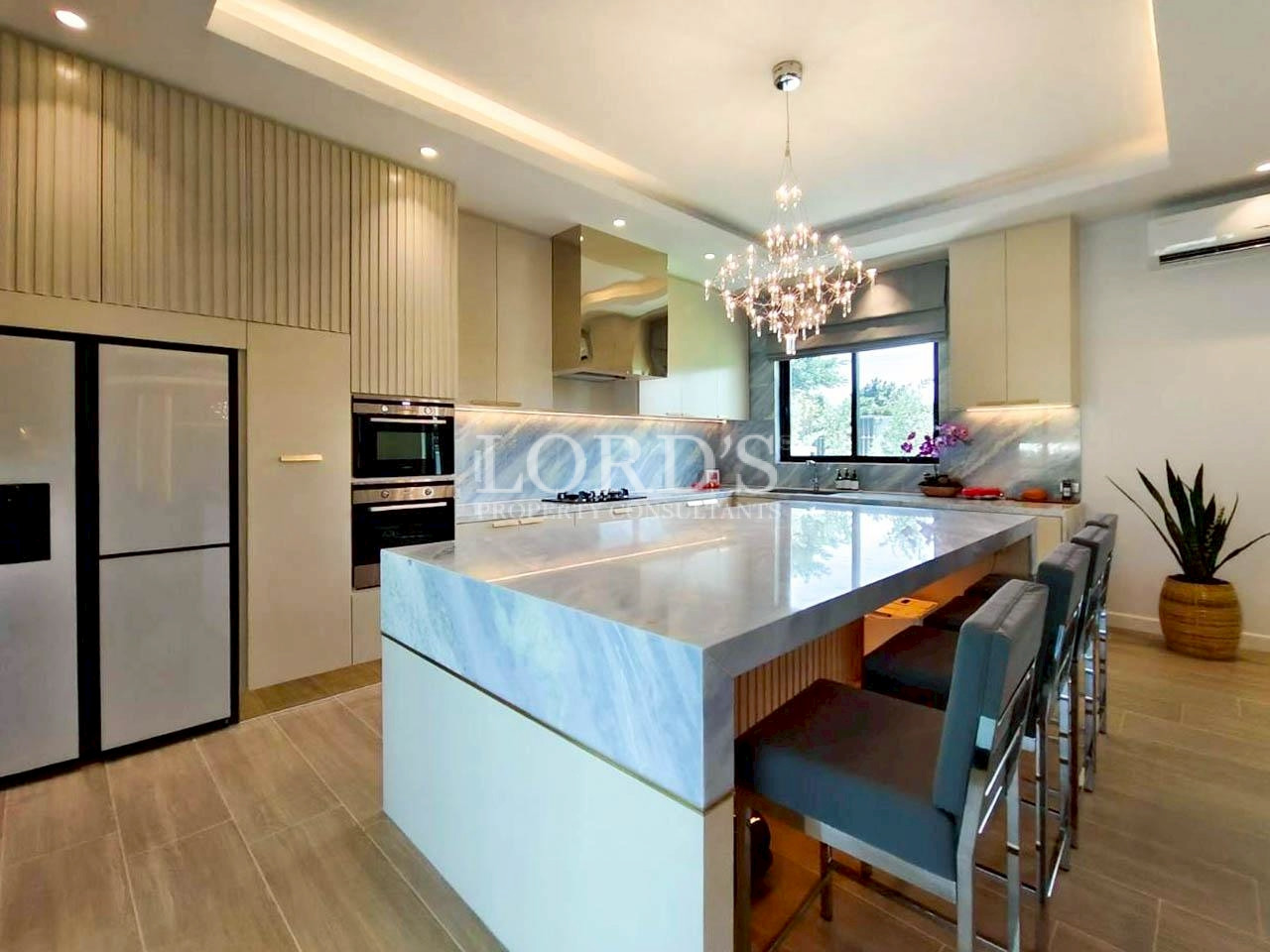 Bright kitchen with marble island and pendant lighting