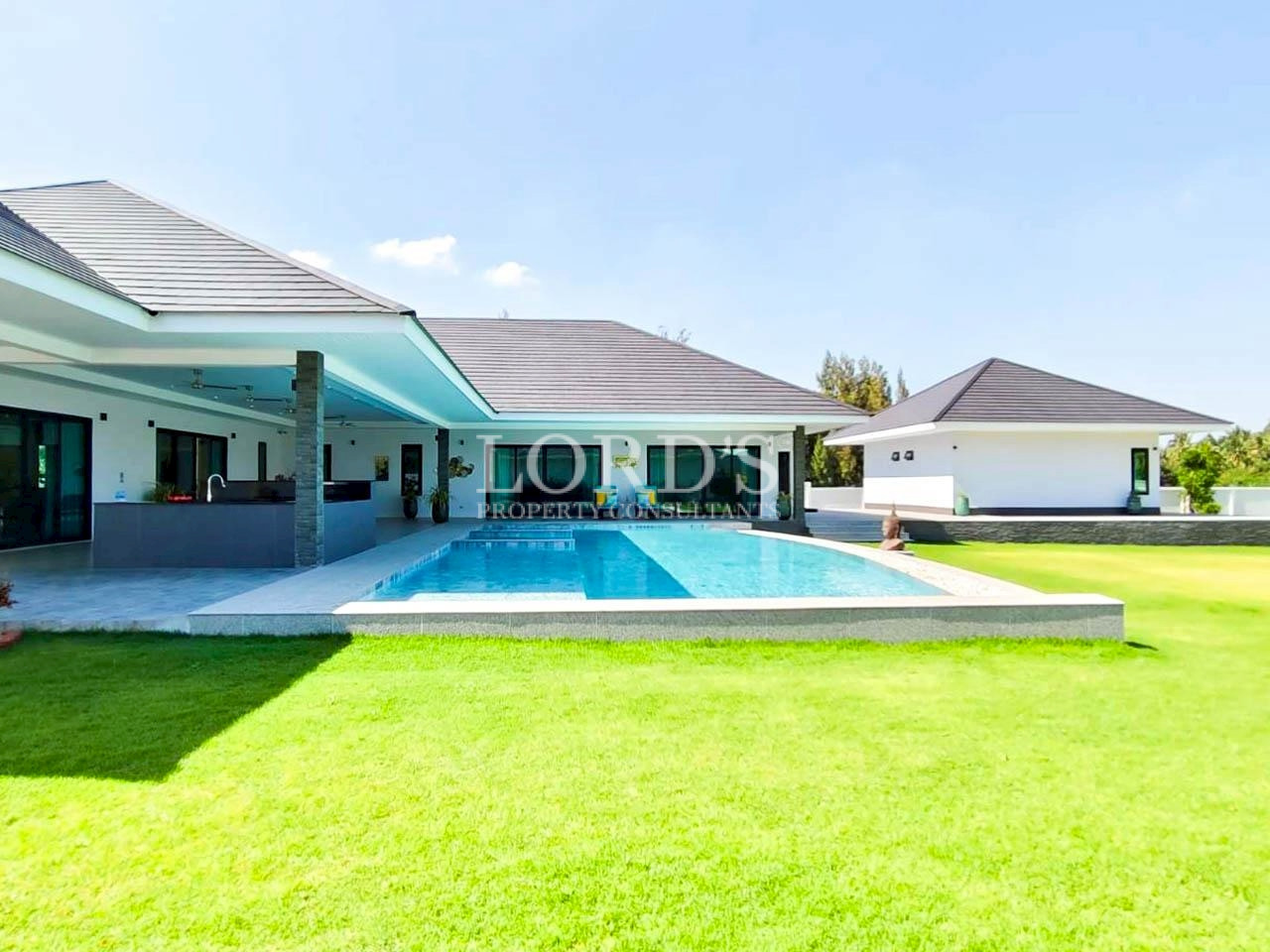 Luxury villa exterior with swimming pool and lawn