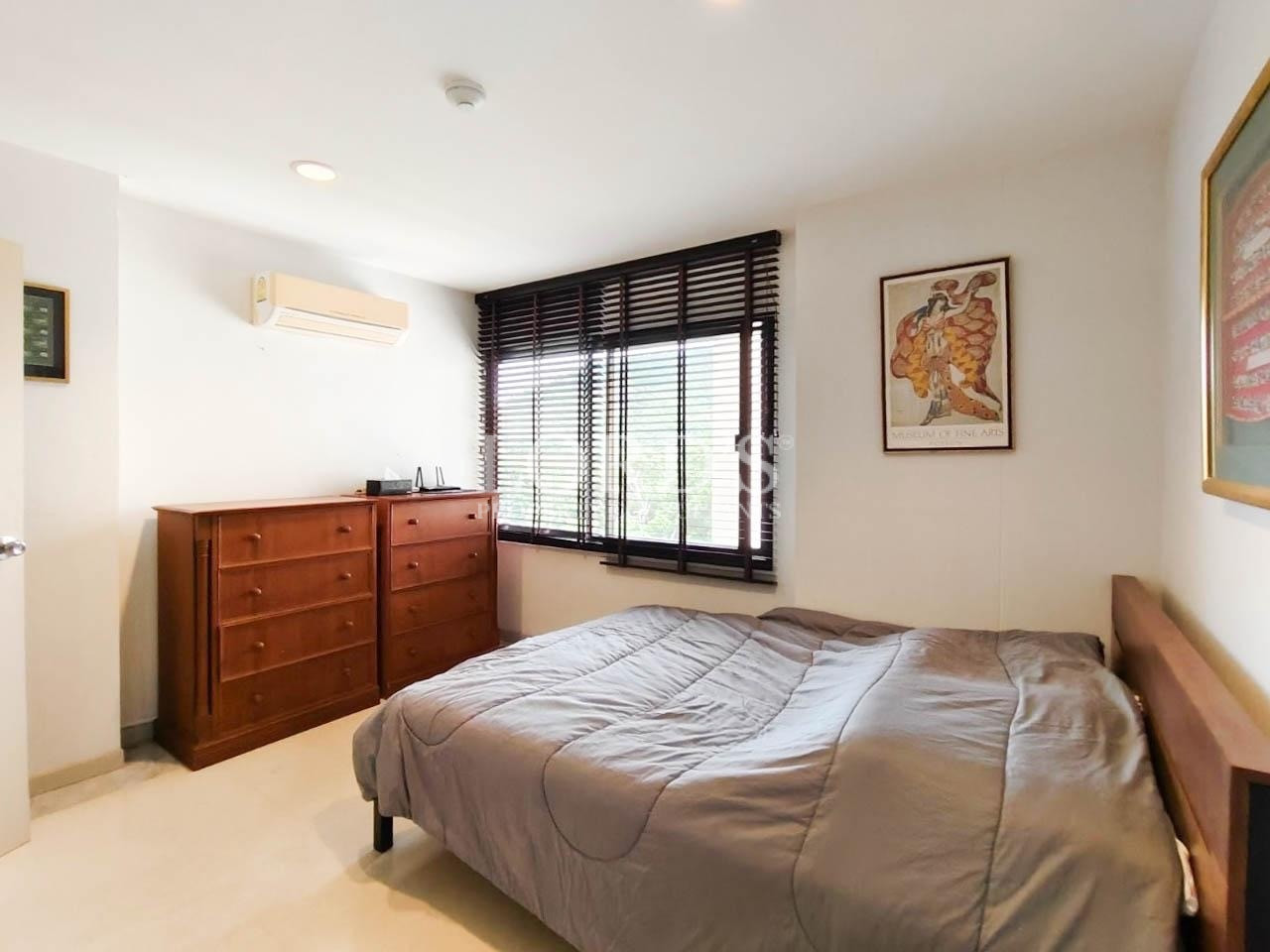 Bedroom with gray bedding and large windows