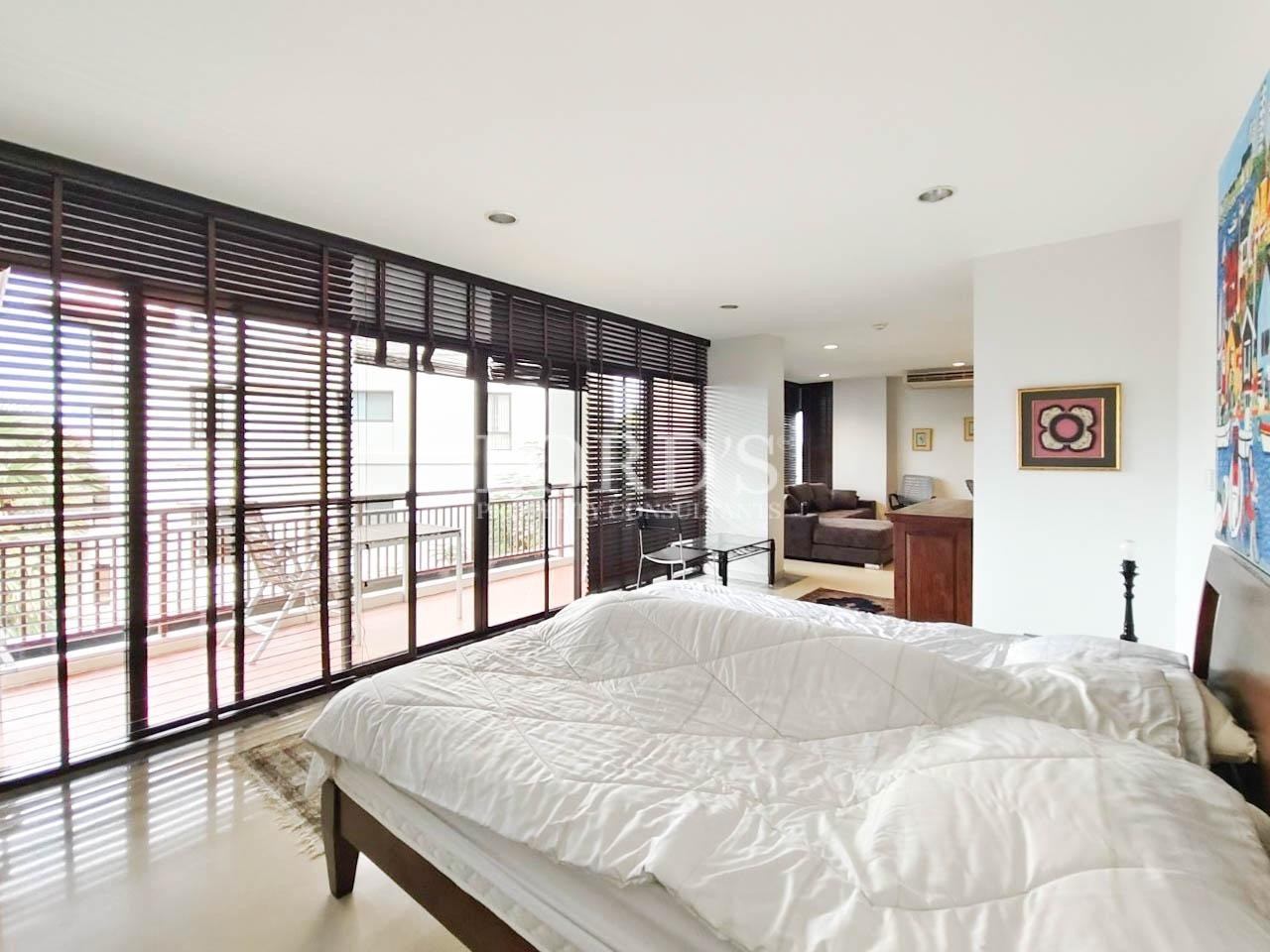 Bedroom with white bedding and large windows