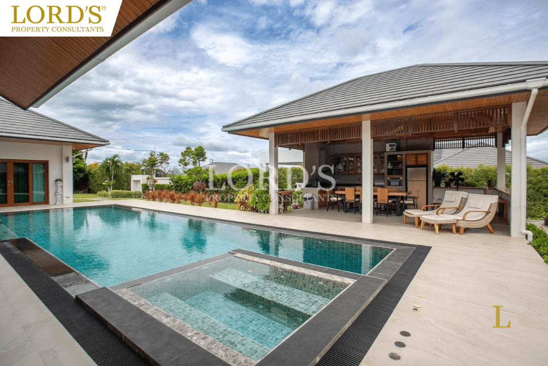 Modern swimming pool with villa and tiled deck