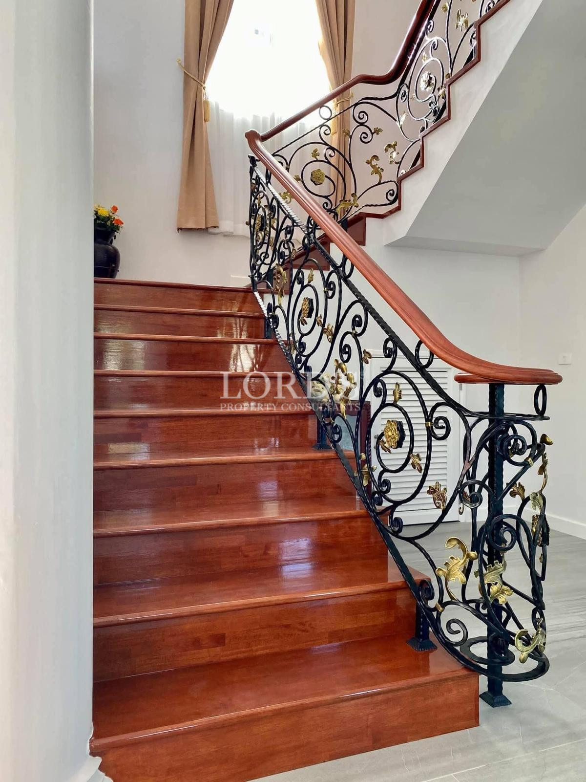 Elegant wooden staircase with wrought iron railing