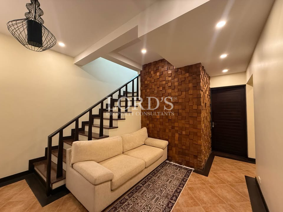 Staircase with beige sofa and warm lighting