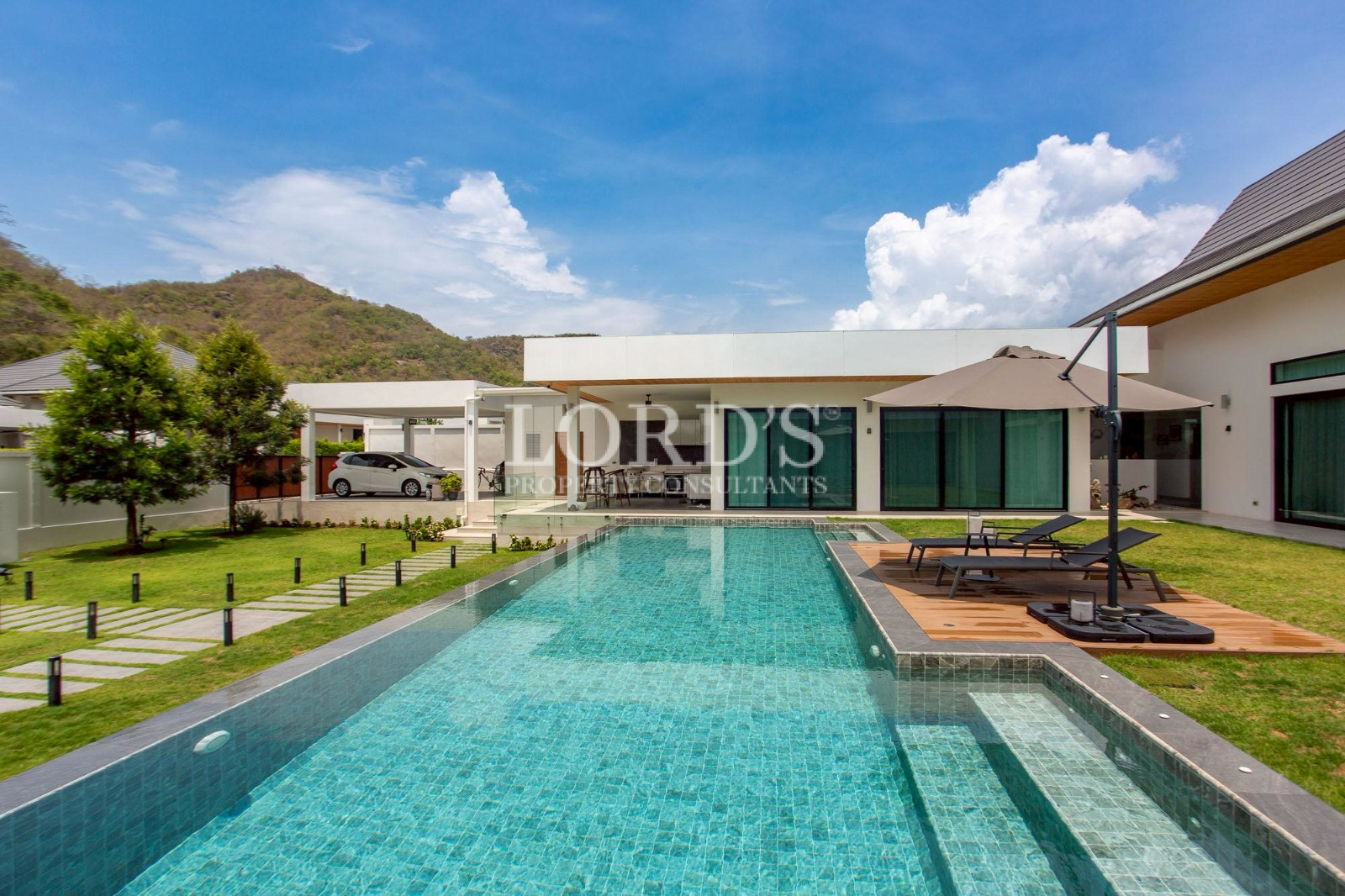 Long rectangular pool beside villa
