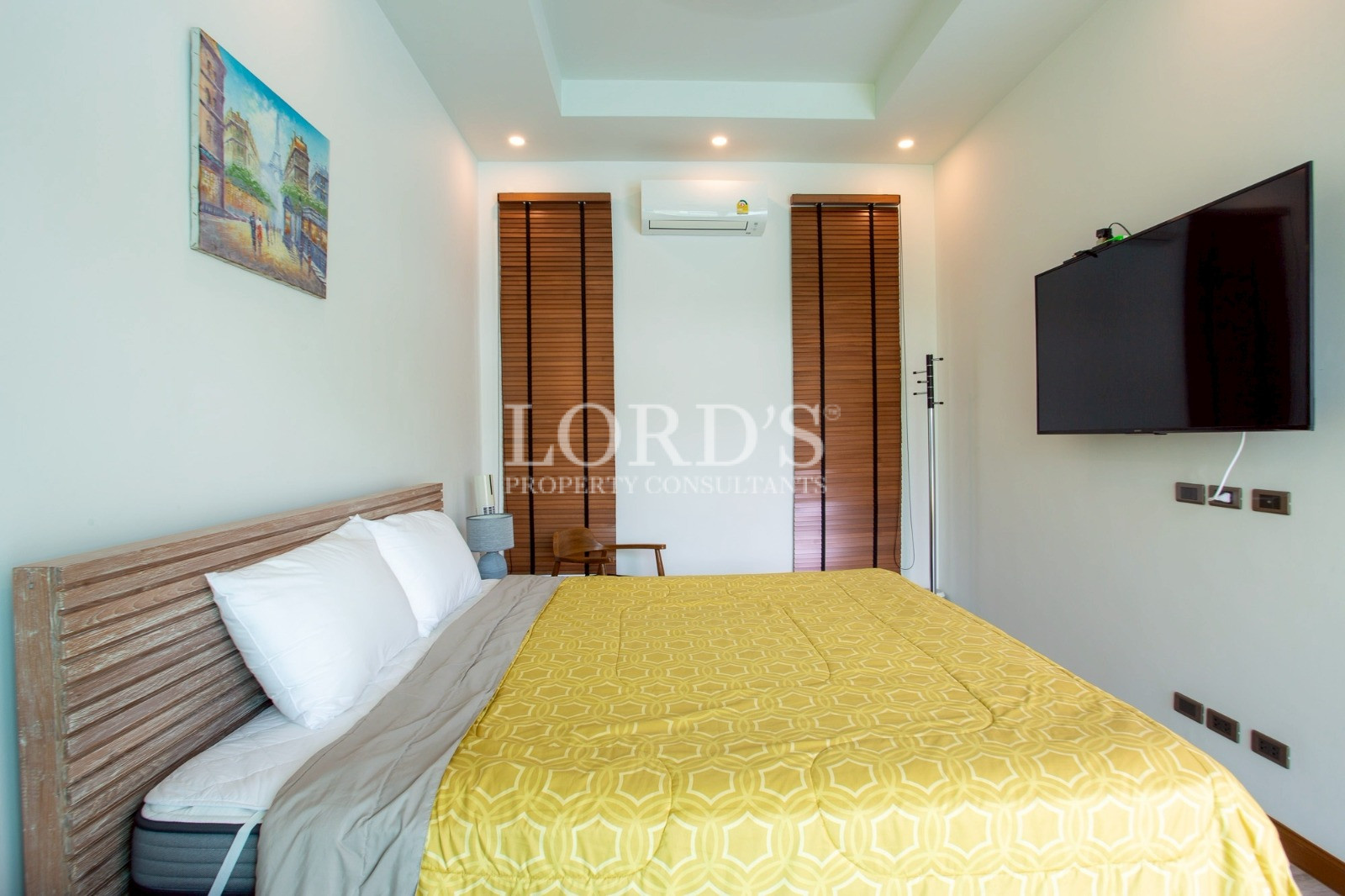 Bedroom with yellow bedspread and wooden wardrobe