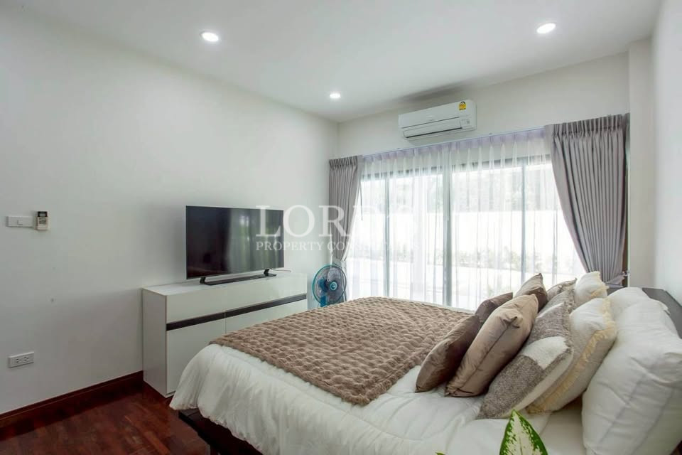 Living room with TV, air conditioning, and curtains