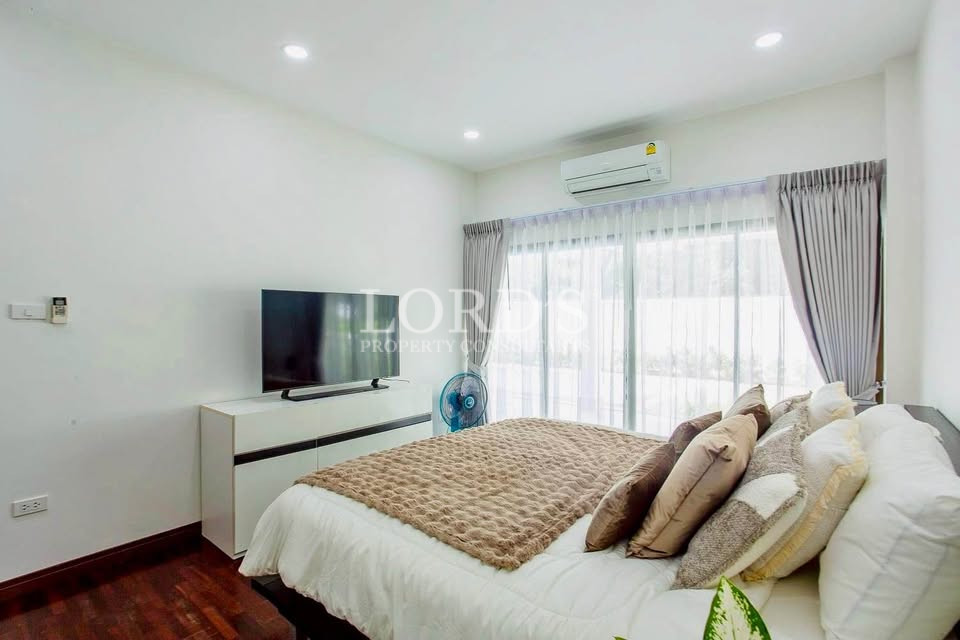Bright bedroom with multiple windows and air conditioning