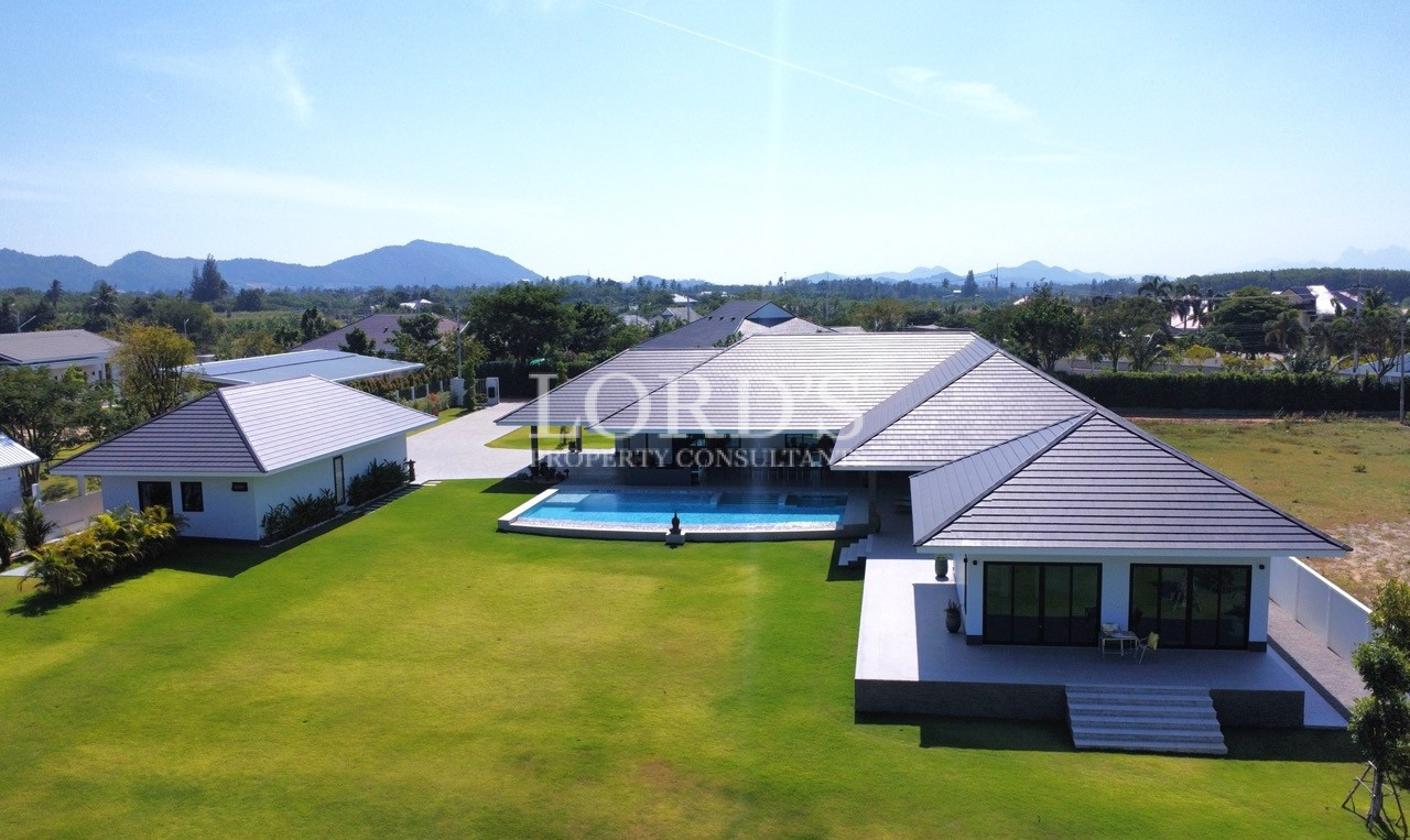 Aerial view of luxury villa with pool and mountains