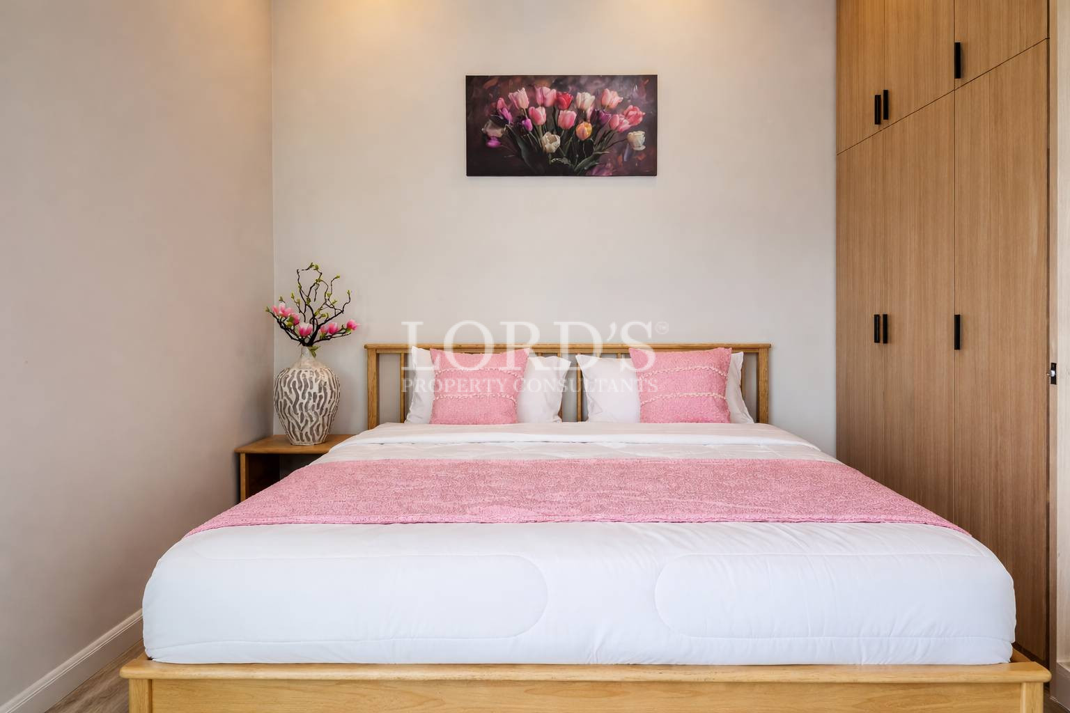 Bedroom with pink bedding and artwork