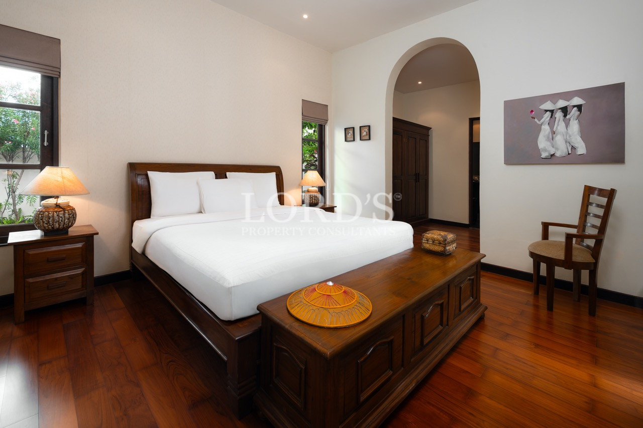 Bedroom with arched doorway and wooden flooring